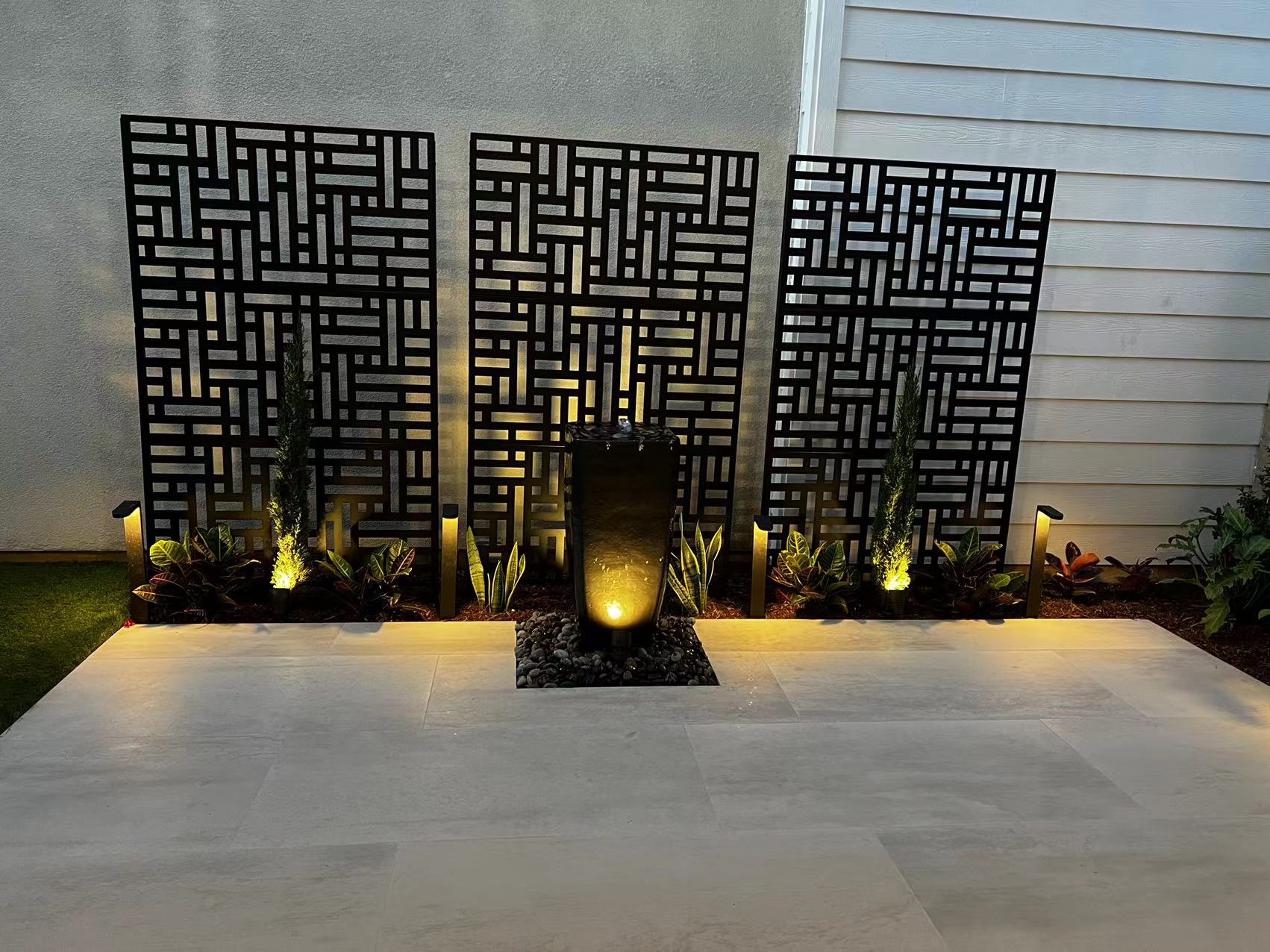 Decorative screen panels and stone water feature at night