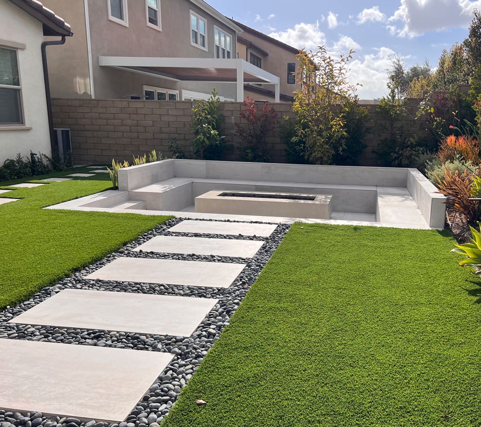 Sunken fire pit bench with stepping stones and turf